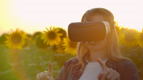 The-woman-is-working-in-VR-glasses.-She-is-engaged-in-the-working-process.-It-is-a-perfect-sunny-day-in-the-sunflower-field.
